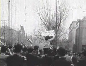 국회의사당 앞의 데모, 한 여대생이 무등을 타고 구호문을 치켜 들었다.1960년 4월 19일